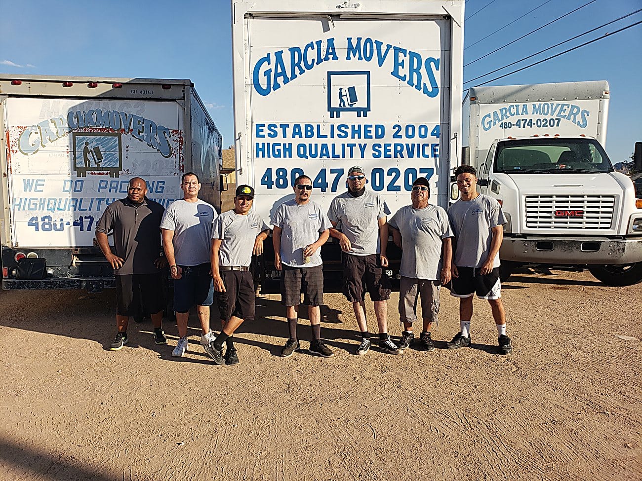 The Garcia Movers crew in front of the company trucks