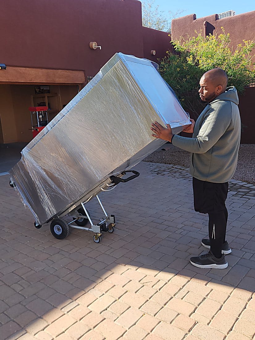 A Garcia mover moving a wrapped piece up to a customer home