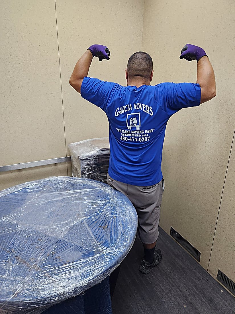 A Garcia mover carefully wrapping a table for transport