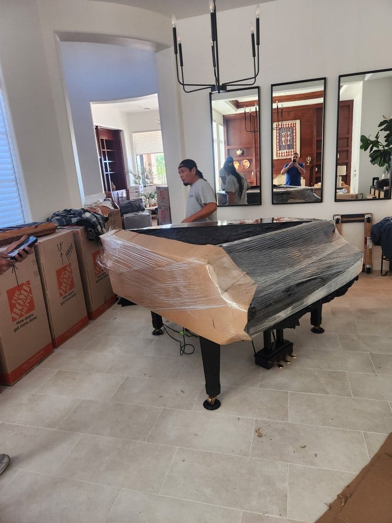 A grand piano padded and wrapped for transport