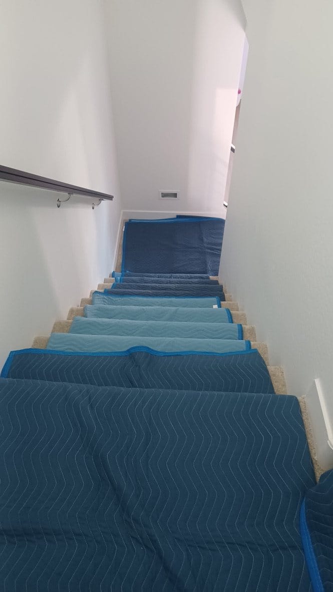 Stairs lined with moving blankets to protect the customer's home